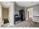 Kitchen features black appliances, gray walls and hardwood floors, adjacent to a stairway entrance at 6107 Rural Dr, Indianapolis, IN 46227