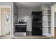 Open kitchen layout with black appliances, grey walls, and hardwood floors leads to an exterior door at 6107 Rural Dr, Indianapolis, IN 46227