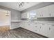 Modern kitchen featuring white cabinets, laminate countertops, backsplash, and dining area view at 6107 Rural Dr, Indianapolis, IN 46227
