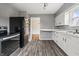 A well-lit kitchen featuring white cabinets, gray walls, stainless steel appliances, and hardwood floors at 6107 Rural Dr, Indianapolis, IN 46227