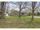 Expansive yard with mature trees surrounding a cozy single story home and long driveway at 6107 Rural Dr, Indianapolis, IN 46227