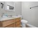 Half bathroom featuring hardwood cabinets, marble sink, toilet and well-lit mirror at 621 Fireside Dr, Greenwood, IN 46143