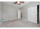 A neutrally decorated bedroom with a ceiling fan and a carpeted floor with sliding door closet at 621 Fireside Dr, Greenwood, IN 46143