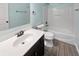 Modern bathroom with a white sink, dark cabinets, neutral walls, and a combination shower and tub at 6234 N Woods Edge Dr, McCordsville, IN 46055