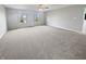 Spacious bedroom features a ceiling fan, neutral paint, and carpeted floors with a view of the outdoors through two windows at 6234 N Woods Edge Dr, McCordsville, IN 46055