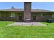A brick home exterior with a patio area, outdoor bench, and large well-kept backyard at 6318 Dahlia Dr, Indianapolis, IN 46217