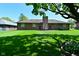 Exterior view of a home showcasing a large backyard, brick exterior, and mature trees at 6318 Dahlia Dr, Indianapolis, IN 46217