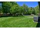 A large backyard showcasing lush greenery and mature trees, bordering the home and fence at 6318 Dahlia Dr, Indianapolis, IN 46217