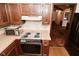 Classic kitchen with wood cabinets, a flat top stove, and a view into an adjacent room at 6318 Dahlia Dr, Indianapolis, IN 46217