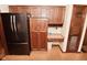 Kitchen featuring wood cabinets, a modern black refrigerator, and a built-in desk area at 6318 Dahlia Dr, Indianapolis, IN 46217