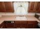 Close-up of a kitchen sink with wooden cabinets and laminate counters at 6318 Dahlia Dr, Indianapolis, IN 46217