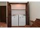 Convenient laundry closet with wood folding doors, showcasing a washer and dryer at 6318 Dahlia Dr, Indianapolis, IN 46217