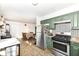 Modern kitchen featuring stainless steel appliances, green cabinetry, and decorative backsplash at 664 N County Road 800 E, Avon, IN 46123