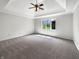 Large bedroom with neutral carpeting, ceiling fan, and natural light from the three windows at 6915 Juliet Dr, Avon, IN 46123