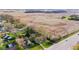 Aerial view of a neighborhood with houses, trees, lawns, and a large open field at 7008 E Jackson St, Muncie, IN 47303