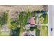 Aerial view of a red-roofed home surrounded by lush greenery and trees at 7008 E Jackson St, Muncie, IN 47303