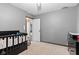 Bedroom area showcasing a crib and chair, next to an open doorway at 7008 E Jackson St, Muncie, IN 47303