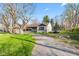 Charming single-story home features a long driveway, stone accents, and a lush green lawn at 7008 E Jackson St, Muncie, IN 47303