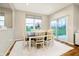 Dining room with a wood table, white chairs, neutral decor, a white rug, and sliding glass doors to the backyard at 7158 Sugar Maple Ln, Brownsburg, IN 46112