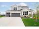 Beautiful two-story home with a three-car garage, gray siding, and manicured landscaping at 7158 Sugar Maple Ln, Brownsburg, IN 46112