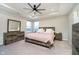 Main bedroom with tray ceiling, ceiling fan, neutral decor, and ensuite bathroom, creating a private retreat at 7158 Sugar Maple Ln, Brownsburg, IN 46112
