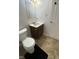 Cozy bathroom features a toilet, sink with storage, and tiled floors at 8006 Sunfield Ct, Indianapolis, IN 46214