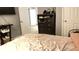 Bedroom view showcasing a neutral pink bedspread, dark wood dresser, and natural light at 8006 Sunfield Ct, Indianapolis, IN 46214