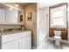 Charming bathroom featuring exposed brick wall, classic white vanity, granite countertop, and tub with shower at 801 N Pennsylvania St # Apt D, Indianapolis, IN 46204