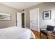 Bedroom with hardwood floors, neutral walls, comfortable bed and chair at 801 N Pennsylvania St # Apt D, Indianapolis, IN 46204