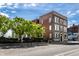 An exterior shot of a brick building with green trees in the front, set against a blue sky at 801 N Pennsylvania St # Apt D, Indianapolis, IN 46204