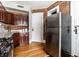 Cozy kitchen featuring stainless steel refrigerator, wood cabinets, exposed brick wall, and hardwood floors at 801 N Pennsylvania St # Apt D, Indianapolis, IN 46204