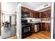Efficient kitchen featuring stainless steel appliances, dark wood cabinetry, and a view into the adjacent dining area at 801 N Pennsylvania St # Apt D, Indianapolis, IN 46204