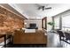 Spacious living room with exposed brick wall, dark hardwood floors, modern lighting, and stylish contemporary furnishings at 801 N Pennsylvania St # Apt D, Indianapolis, IN 46204