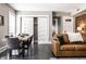 Inviting living room featuring dark wood floors, a brown leather couch, and an adjacent dining area with white closet doors at 801 N Pennsylvania St # Apt D, Indianapolis, IN 46204