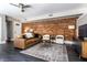 Inviting living area featuring exposed brick, a comfortable leather sofa, an area rug, and abundant natural light at 801 N Pennsylvania St # Apt D, Indianapolis, IN 46204