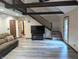 Open living room with beamed ceiling, wooden stairs, and modern floors at 8017 Dogwood Ct, Plainfield, IN 46168