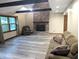 Living room features brick fireplace, modern floors, exposed beams and natural lighting at 8017 Dogwood Ct, Plainfield, IN 46168