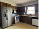Traditional kitchen with wooden cabinets and stainless steel refrigerator and microwave at 8122 Tanager Ct, Indianapolis, IN 46256