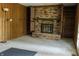 Spacious living room with wood paneling and a brick fireplace that includes built-in bookshelves at 8122 Tanager Ct, Indianapolis, IN 46256