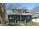 Charming duplex home with a covered front porch and well-maintained front yard and mature trees in the yard at 822 N Bradley Ave, Indianapolis, IN 46201