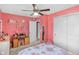 Bright bedroom with colorful decor, ceiling fan, desk, and closet with an open door to another room at 8442 Averly Park Dr, Indianapolis, IN 46237