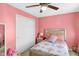 A pink bedroom with a ceiling fan, closet, and decorative touches at 8442 Averly Park Dr, Indianapolis, IN 46237