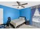 Bedroom with blue walls, a ceiling fan, and coordinated curtains and bedding at 8442 Averly Park Dr, Indianapolis, IN 46237