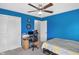 Bedroom with blue walls, a ceiling fan, and workstation at 8442 Averly Park Dr, Indianapolis, IN 46237