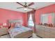 A pink bedroom with a ceiling fan, dresser, and decorative touches at 8442 Averly Park Dr, Indianapolis, IN 46237
