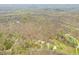 Aerial shot of a property featuring a home, barn, and lush surroundings within a canopy of mixed trees and winding roads at 8503 Bean Blossom Rd, Trafalgar, IN 46181