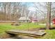 Spacious backyard with a wooden bridge, green home, and red outbuilding at 8503 Bean Blossom Rd, Trafalgar, IN 46181