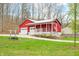 Exterior view of the barn, showcasing its large garage doors and charming front porch at 8503 Bean Blossom Rd, Trafalgar, IN 46181