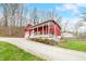 Exterior view of the red barn, with a spacious driveway and well-maintained lawn at 8503 Bean Blossom Rd, Trafalgar, IN 46181