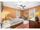 Warm bedroom with two windows, a fan, a large bed, and a patterned chair at 8503 Bean Blossom Rd, Trafalgar, IN 46181